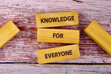 Education Concept text KNOWLEDGE FOR EVERYONE is assembled from blocks on wooden boards, top view