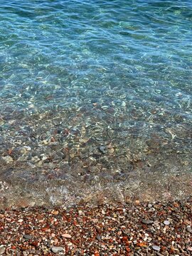 Blue sea waves on pebble beach.