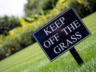 Keep Off the Grass sign on a nicely kept lawn in a park