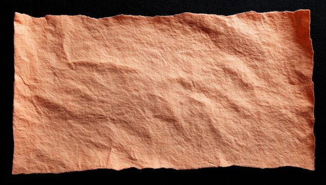 A textured, light peach-colored piece of fabric or paper with a crinkled surface and uneven, torn edges, set against a dark background