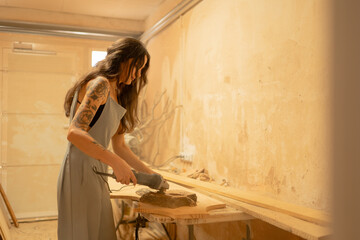 Carpenter sanding wood in workshop using power tool