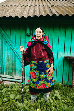 Senior woman stNDING in front of barn