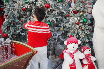 a boy standing on christmas tree