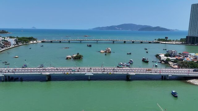 Aerial view of Cau Xom Bong and Cau Tran Phu bridges across Cai river with boats and islands in Nha Trang city, Vietnam.