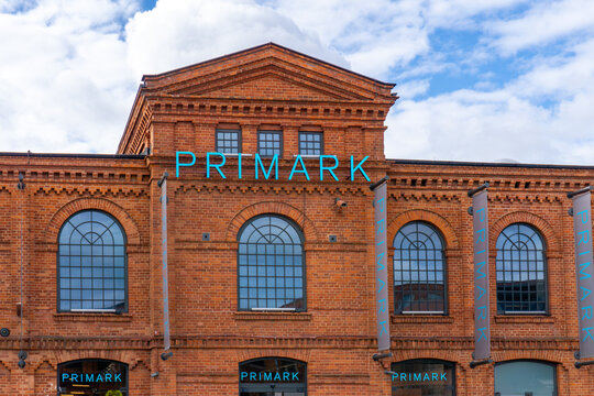 Facade of Primark store at Manufaktura in Ł&oacute;dź, red brick architecture, arched windows, and blue fashion brand signage.