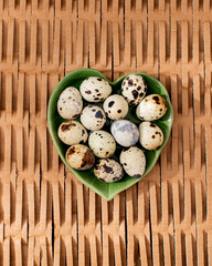 Heart-shaped bowl cradles speckled quail eggs, symbolizing renewal during Nowruz and culinary artistry for Japanese New Year