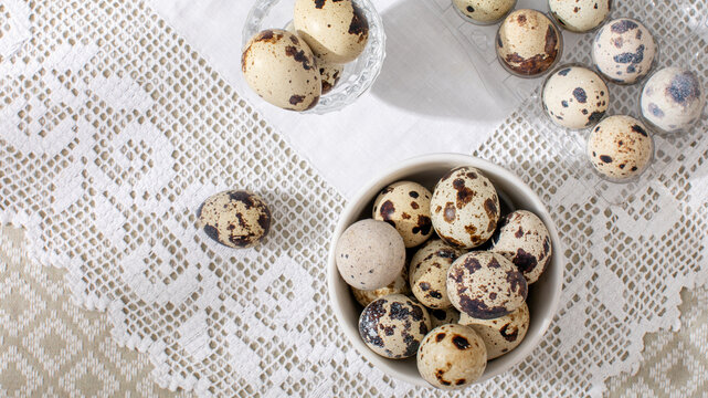 Speckled quail eggs on lace evoke rustic spring festivals, Easter crafting, and culinary artistry's delicate canvas