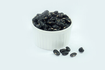 Black beans in a bowl on a white background.