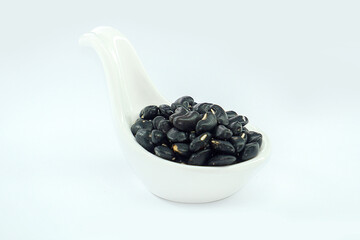 Black beans in a bowl on a white background.