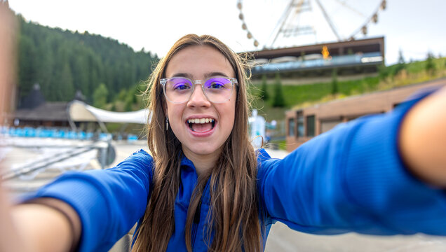 Selfie girl with arms outstretched. Lively shot by the wheel