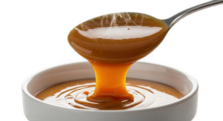 Caramel sauce pouring from a spoon isolated on transparent background, a sweet dessert topping