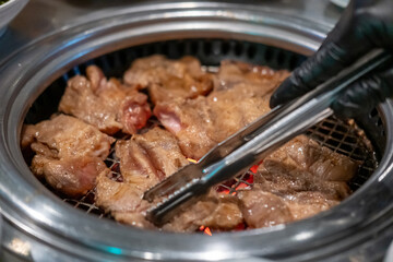 Korean Style Barbecue on stainless grill. BBQ rare meat with soft focus