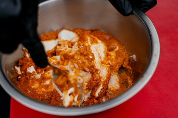 Spiced chicken marinating in yogurt and seasoning mixture in metal bowl, flavorful preparation for barbecue, home cooking, traditional food recipes and festive meat dishes