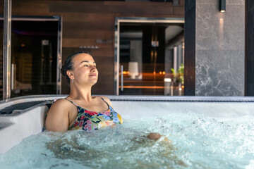 Woman in hot tub with closed eyes breathing calm. Slow wellness pause.