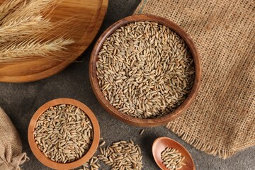 Rye grains and spikes on grey table, flat lay