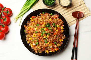 Tasty fried rice and chopsticks on white marble table, flat lay