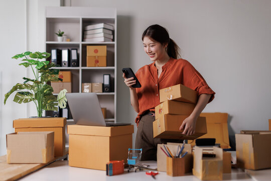 Startup small business sme entrepreneur or freelance Asian woman or Young success Asian woman with her online marketing packaging box and sme delivery.
