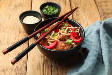 Tasty noodles with chicken and vegetables served on wooden table