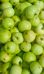 A pile of fresh green apples in a natural style representing healthy eating and harvest season