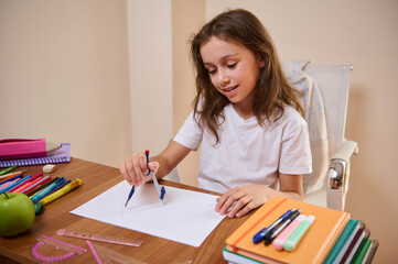 Young Girl Drawing with A Compass at a Study Desk