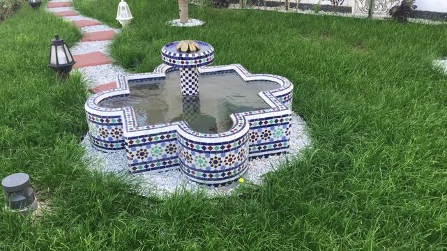 Moroccan fontaine, made of traditional colorful zelig in the home backyard garden.