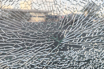 Close-up of broken safety glass with clear central impact point, symbolizing psychological trauma, aggression, and mental breakdown
