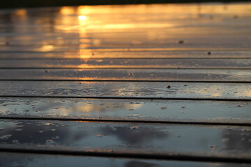 Sunset reflected on wet wooden surface