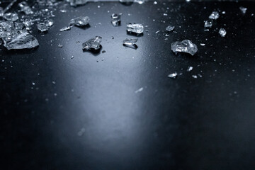 Shattered glass fragments on dark surface