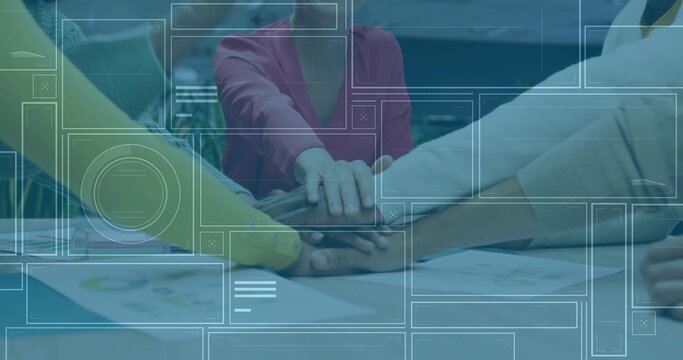 Uniting five professionals joining hands on wooden conference table with charts, digital overlay