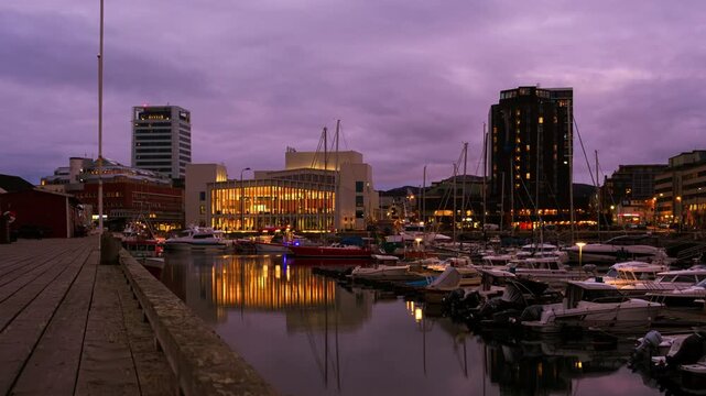 Bodo, Norway. View of the marina in the city center of Bodo, Norway with modern buildings at the background. Time-lapse at sunset