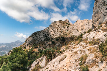 Close-up view of a rocky mountain summit in the Sierra de Bernia, Alicante, Spain. Dramatic limestone formation rising against the clear Mediterranean sky.