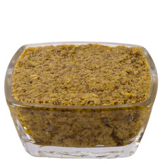 Isolated pesto sauce in a glass saucepan, side view