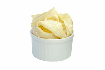 Tofu sheets in a cup placed on a white background.