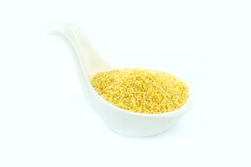 Millet in a White spoon-shaped cup on a white background.