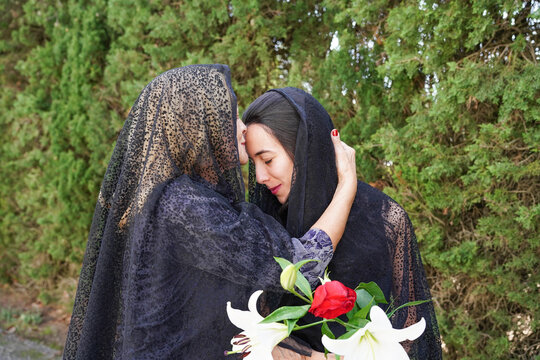 Mother and daughter mourning together in the cemetery