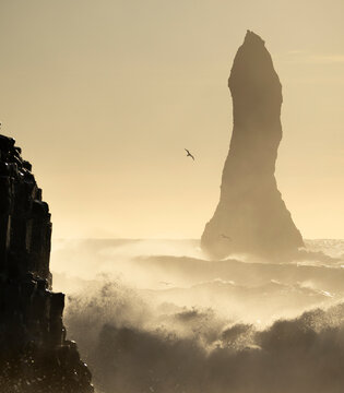 Towering sea stack amidst crashing ocean waves