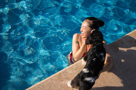 Woman enjoying pool time with her dog companion