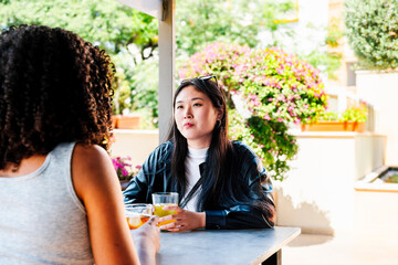 Women friends enjoying drinks outdoors at a social gathering