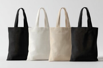Four plain canvas tote bags in black, white, cream, and dark grey