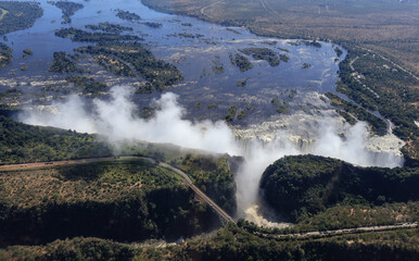 An aerial view of the Zambezi in flood at the Victoria fall with the road and bridge between Zimbabwe and Zambia
