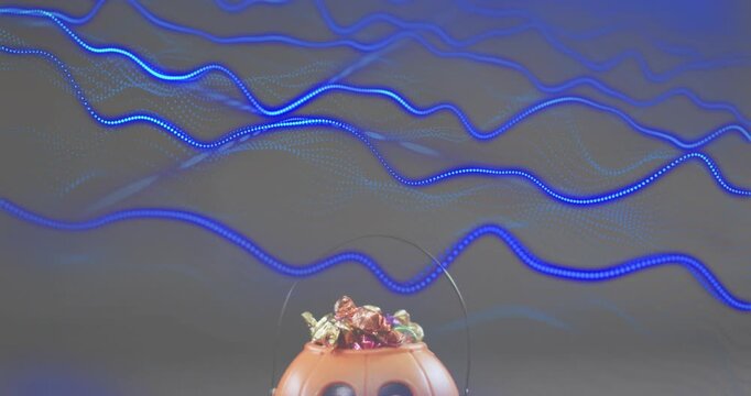 LED waves shifting across grey backdrop and highlighting pumpkin candy bucket below center