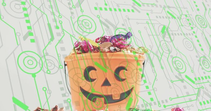 At start bucket on white with green circuits, candies settling and wrappers tumbling under weight