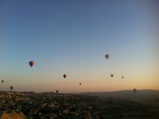 Hot Air Balloons Over Town and Rock Formations at Sunrise in Cappadocia, Turkey