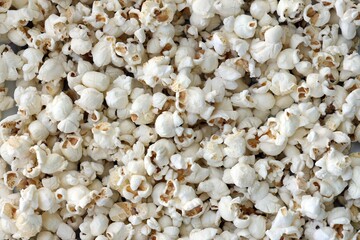 Big amount of salted popcorn in warm yellow tones