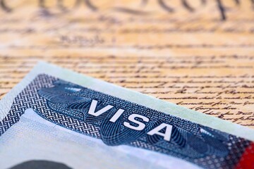 US visa stamped on a passport page with USA Constitution page background