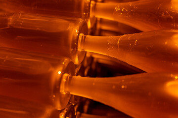 Cave à champagne avec lumière tamisée orange, bouteilles stockées dans des casiers...