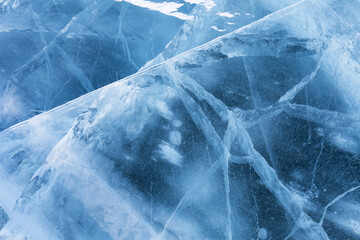Abstract natural blue ice background with white cracks and bubbles pattern of frozen Lake Baikal on cold winter day. Can be used for Christmas winter design. Сopy space, flat lay, blank, top view