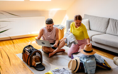 Travelling with pets. Young couple going on a trip with their dog in pet carrier