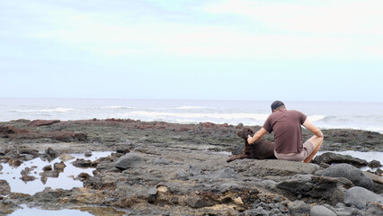 A Man and His Dog Are Enjoying a Peaceful and Serene Moment at the Beautiful Seaside
