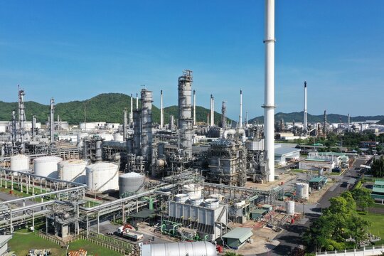 Aerial view of oil refinery or chemical factory and power plant with many storage tanks and pipelines. Business and petrochemical plants, oil storage tanks and for energy and steel pipes.
